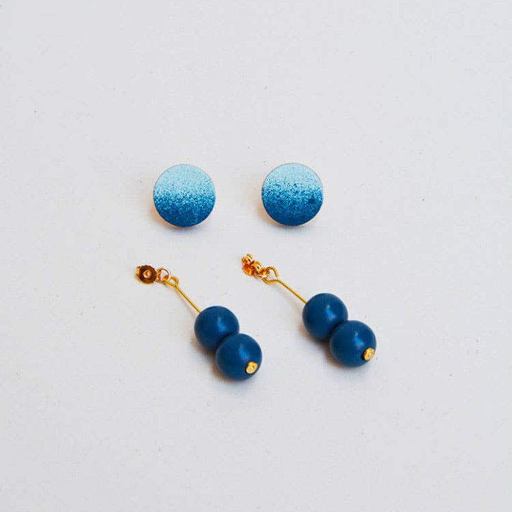 Pair of blue and gold earrings on a light gray background