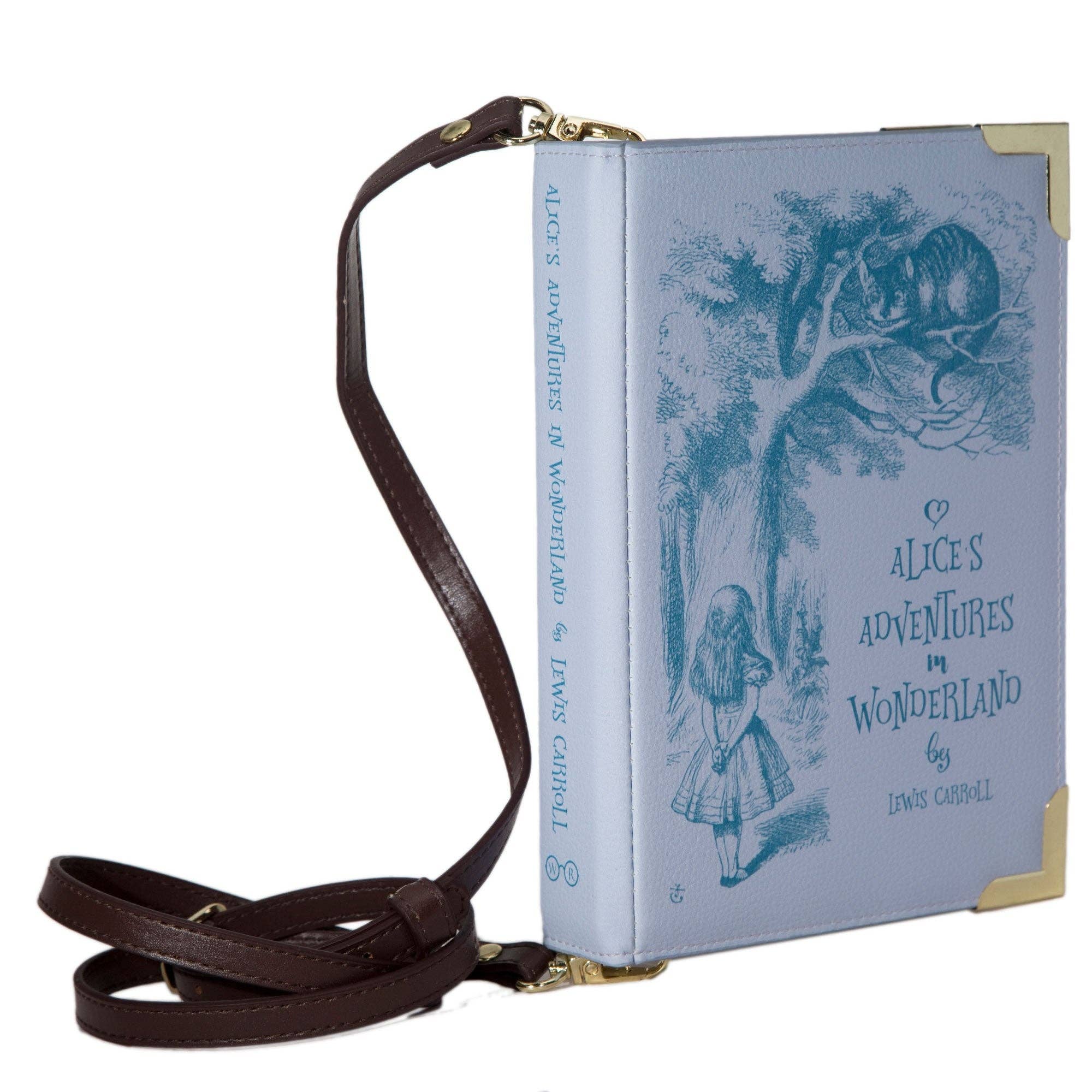 A purple faux-leather crossbody bag designed to look like a vintage Alice in Wonderland book, featuring a dark brown leather shoulder strap and gold-tone hardware.