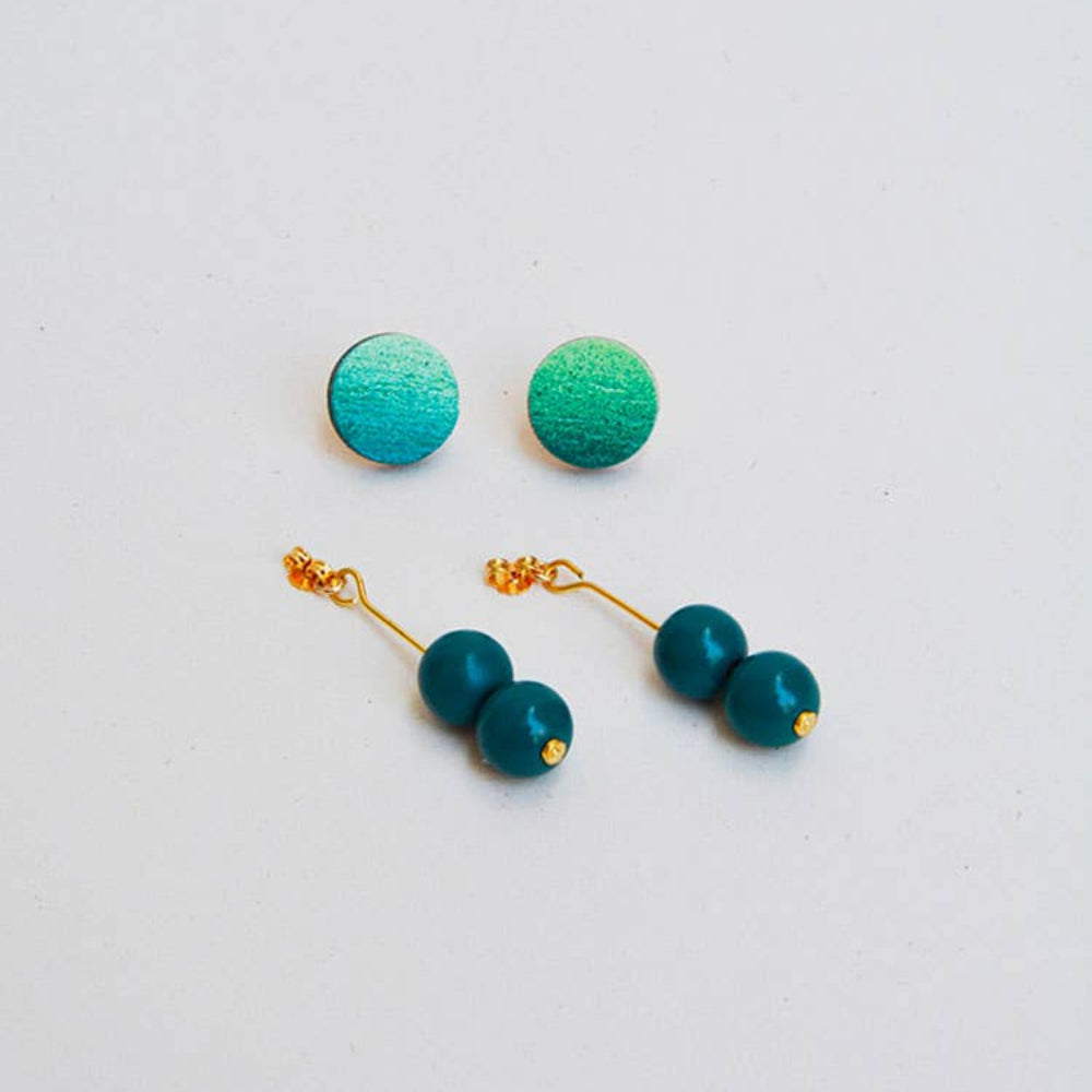 Teal earrings with gold accents on a light gray background