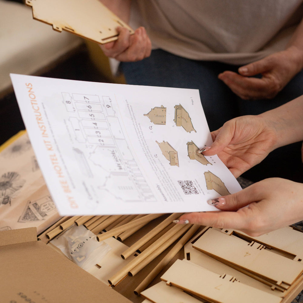 Person assembling wooden puzzle pieces with a manual