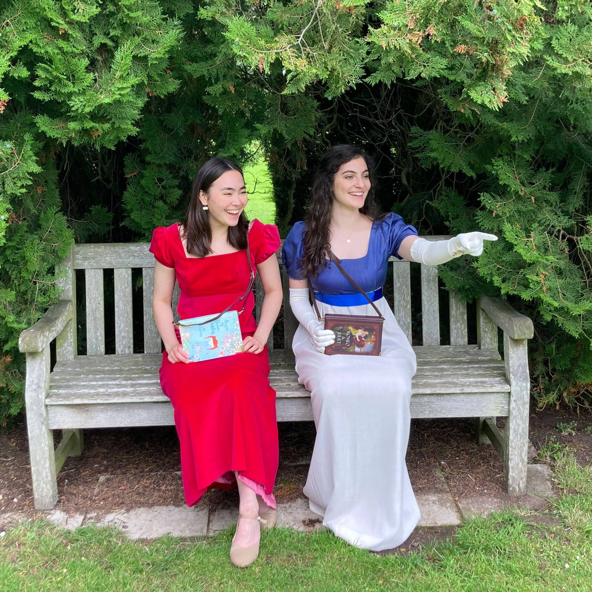 Book-shaped handbag with 'Anne of Green Gables' held by two models on a bench