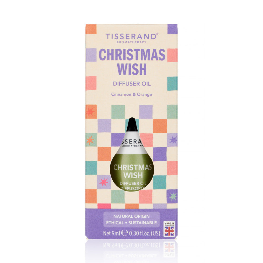 Tisserand Apothecary 'Christmas Wish' diffuser oil in its original packaging, featuring a cream-colored box with a pastel checkerboard pattern and a green glass dropper bottle visible through a cutout.