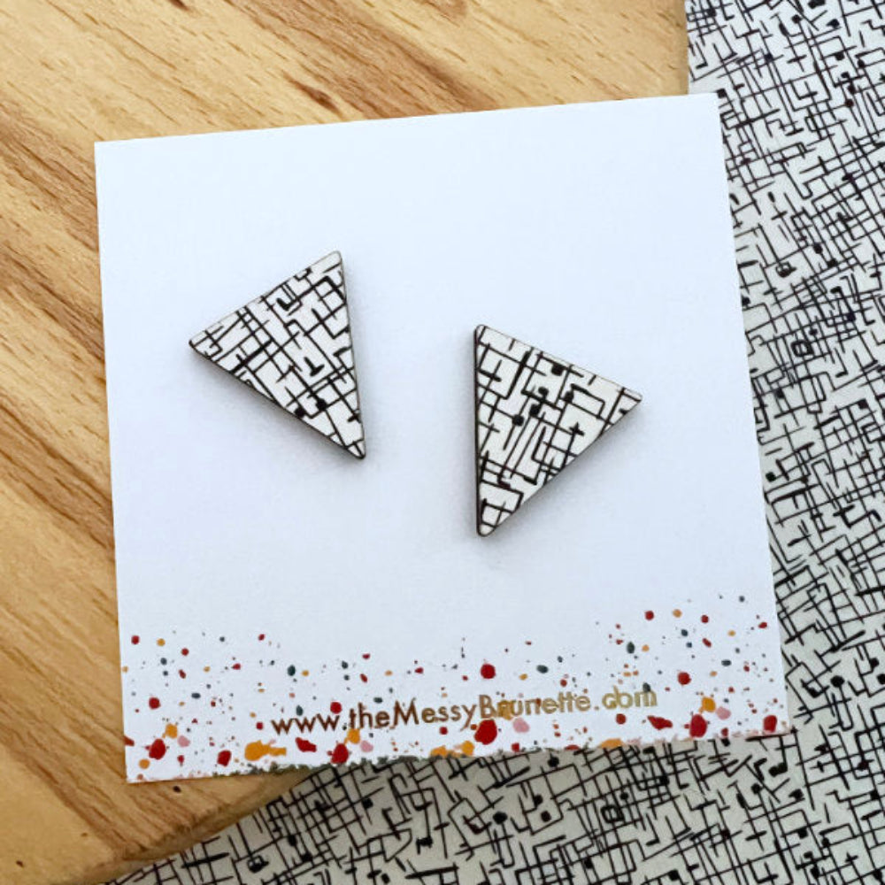 Triangle-shaped earrings on a card with a patterned background