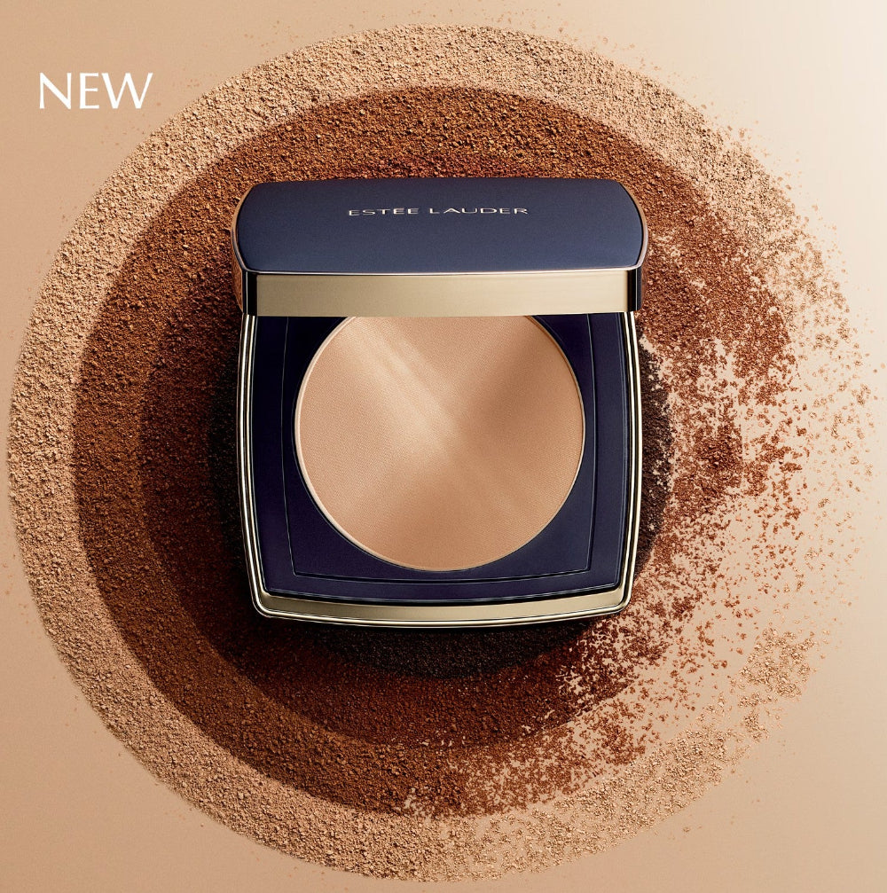 Estée Lauder powder compact surrounded by powder on a beige background