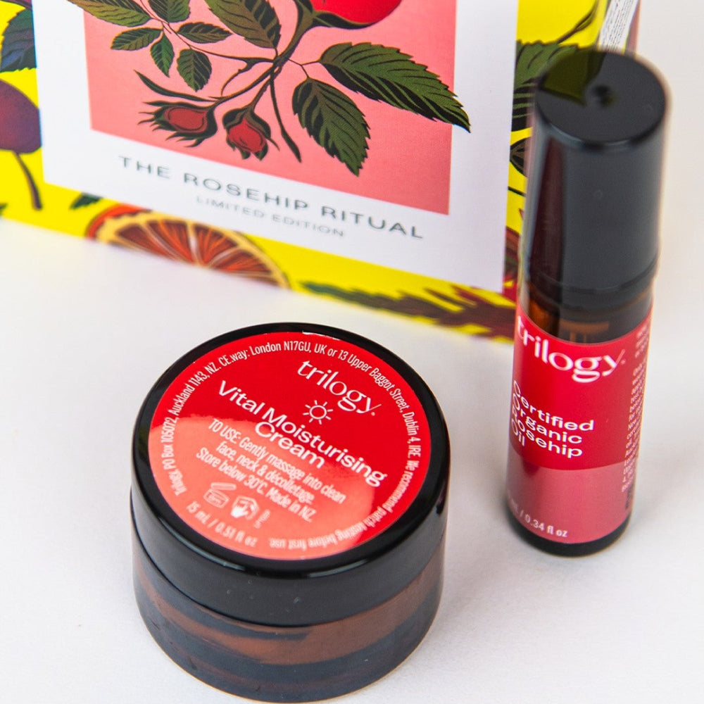 Trilogy skincare products including a jar and a bottle with a colorful box in the background.