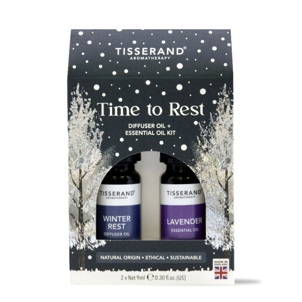 Tisserand Aromatherapy 'Time to Rest' diffuser oil and essential oil kit in a black gift box with white snowflake and tree illustrations, containing Winter Rest and Lavender bottles.