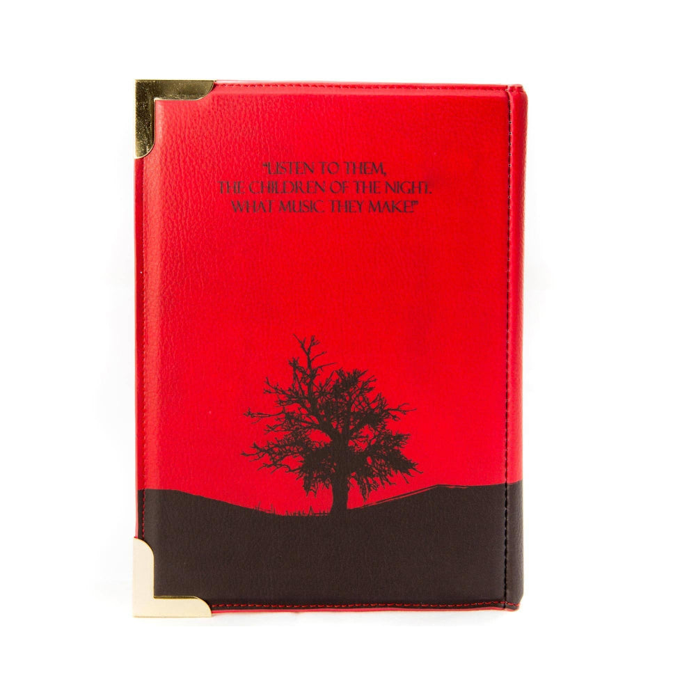 Red notebook with black tree design and text on a white background