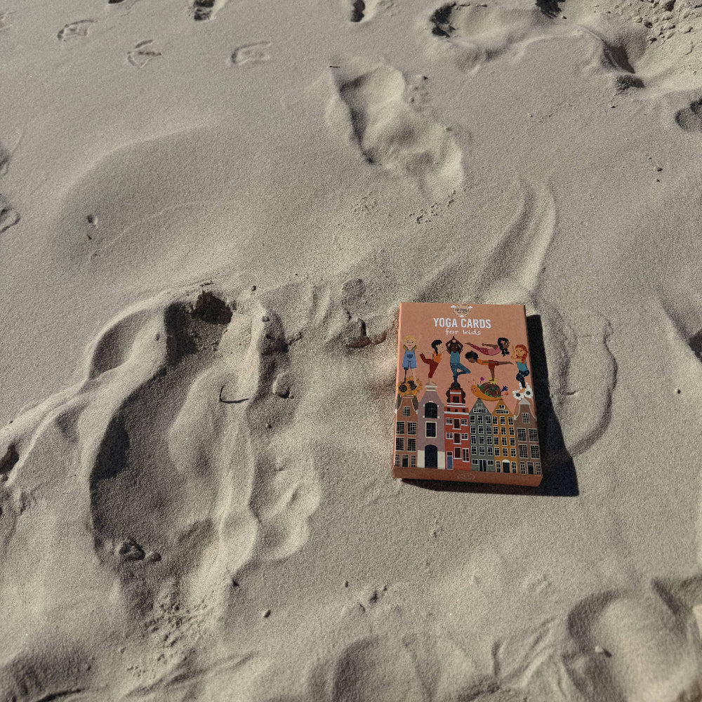 Yoga cards on sand with footprints