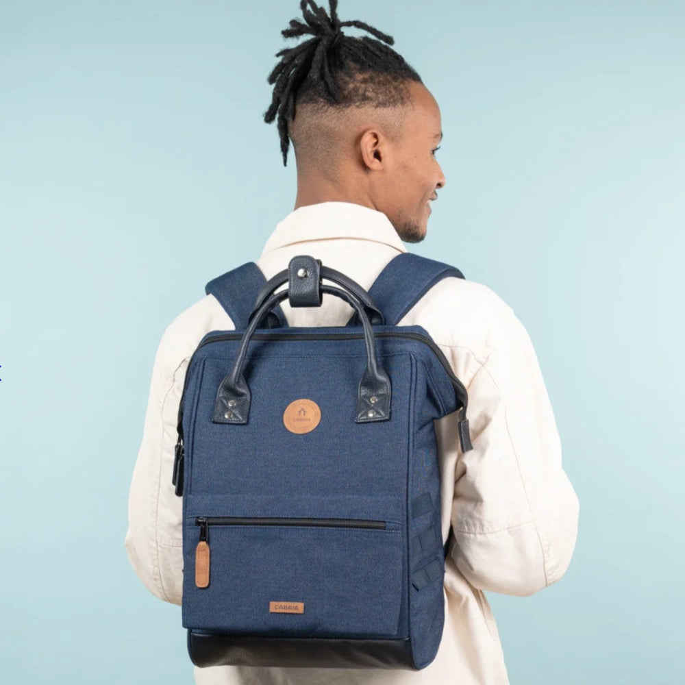 Man wearing a blue backpack against a light blue background