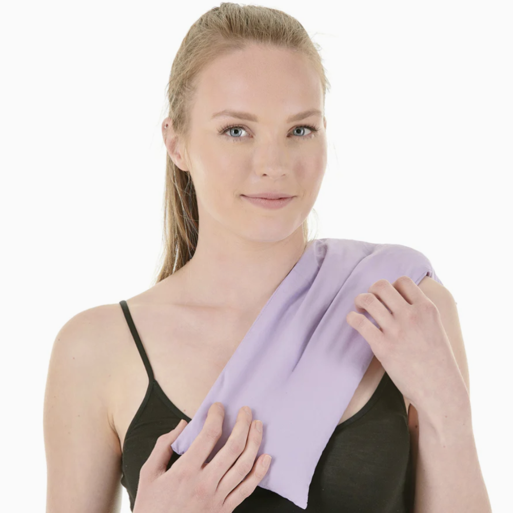 Woman holding a purple towel over her shoulder against a white background