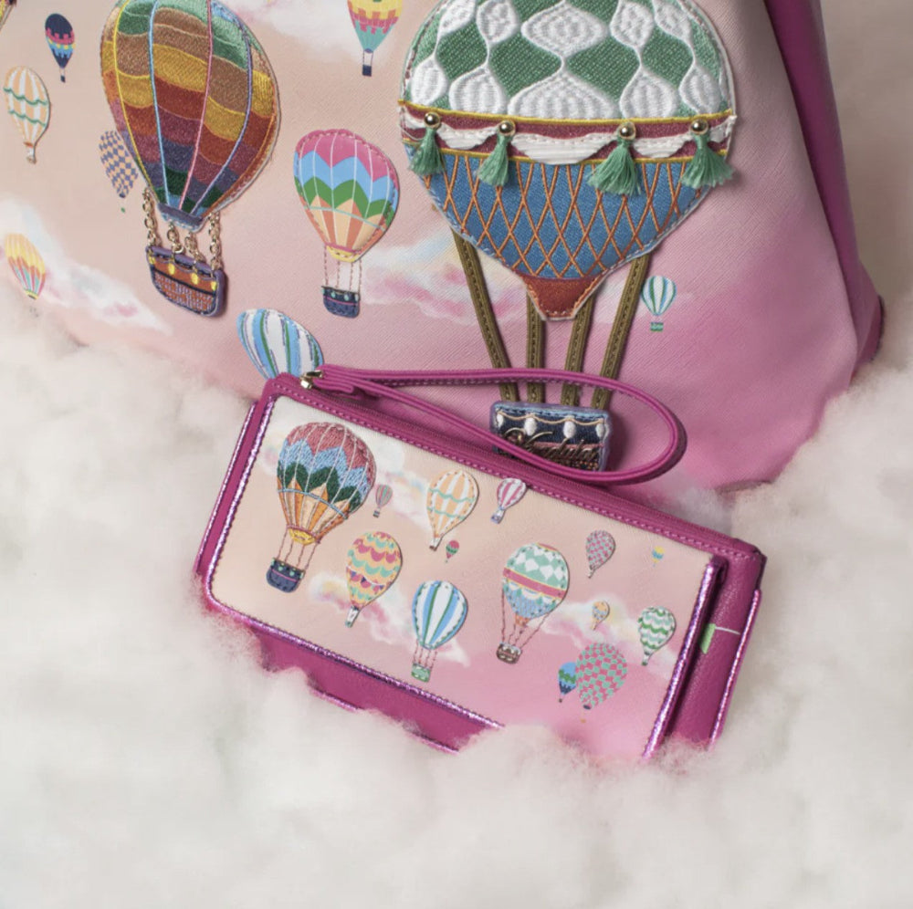 Pink wallet with hot air balloon design on a pink background