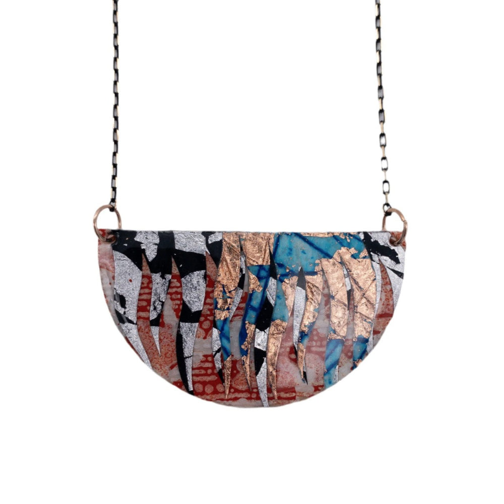 Semi-circular pendant with abstract design on a chain against a white background