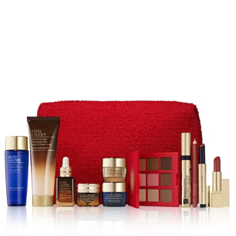 A luxury skincare and makeup gift set arranged in front of a red textured pouch on a white background. The set includes Estée Lauder products such as Advanced Night Repair, Advanced Serums and Treats, and Advanced Eye Cream, alongside a red eyeshadow palette, lip gloss, and a red lipstick.