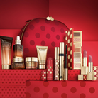 Estée Lauder cosmetic products on a red background with polka dots