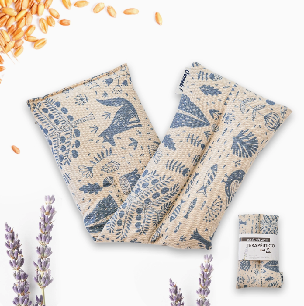 Two folded bean bags with blue animal patterns on beige fabric, surrounded by lavender and sunflower seeds.