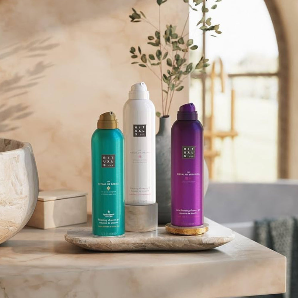 Three hair care products on a marble surface with a neutral background