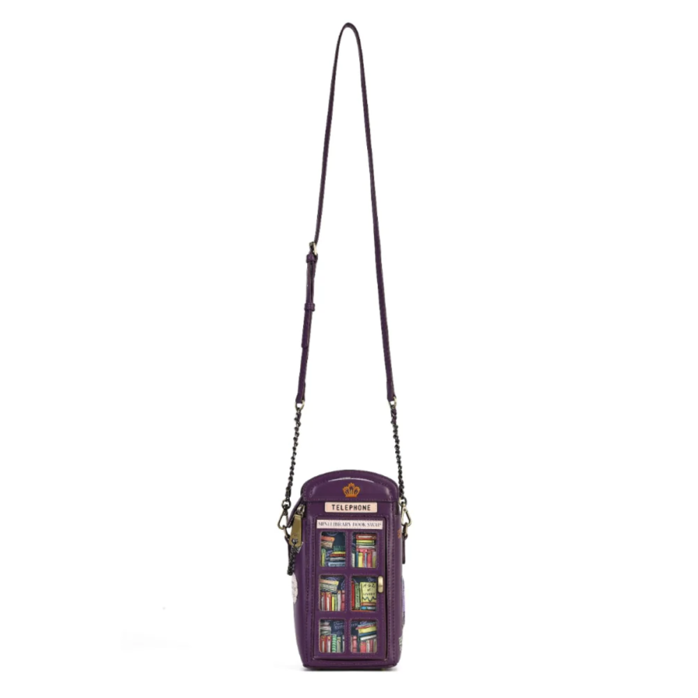 A purple crossbody phone bag featuring a detailed illustration of a classic purple telephone booth with colorful book spines on the front, complete with a long purple strap and gold-tone chain links.