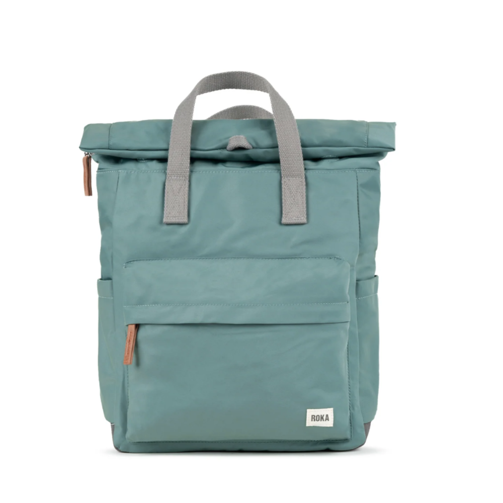 A medium-sized blue backpack with a roll-top design, made from recycled canvas material, featuring a front pocket and branded metal hardware.
