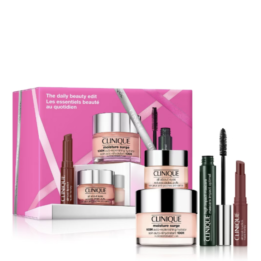 Clinique Beauty Essentials gift set featuring a pink box and multiple cosmetic items including a moisturizer jar, eye cream, brow product, lip tint, and mascara, arranged on a white background.