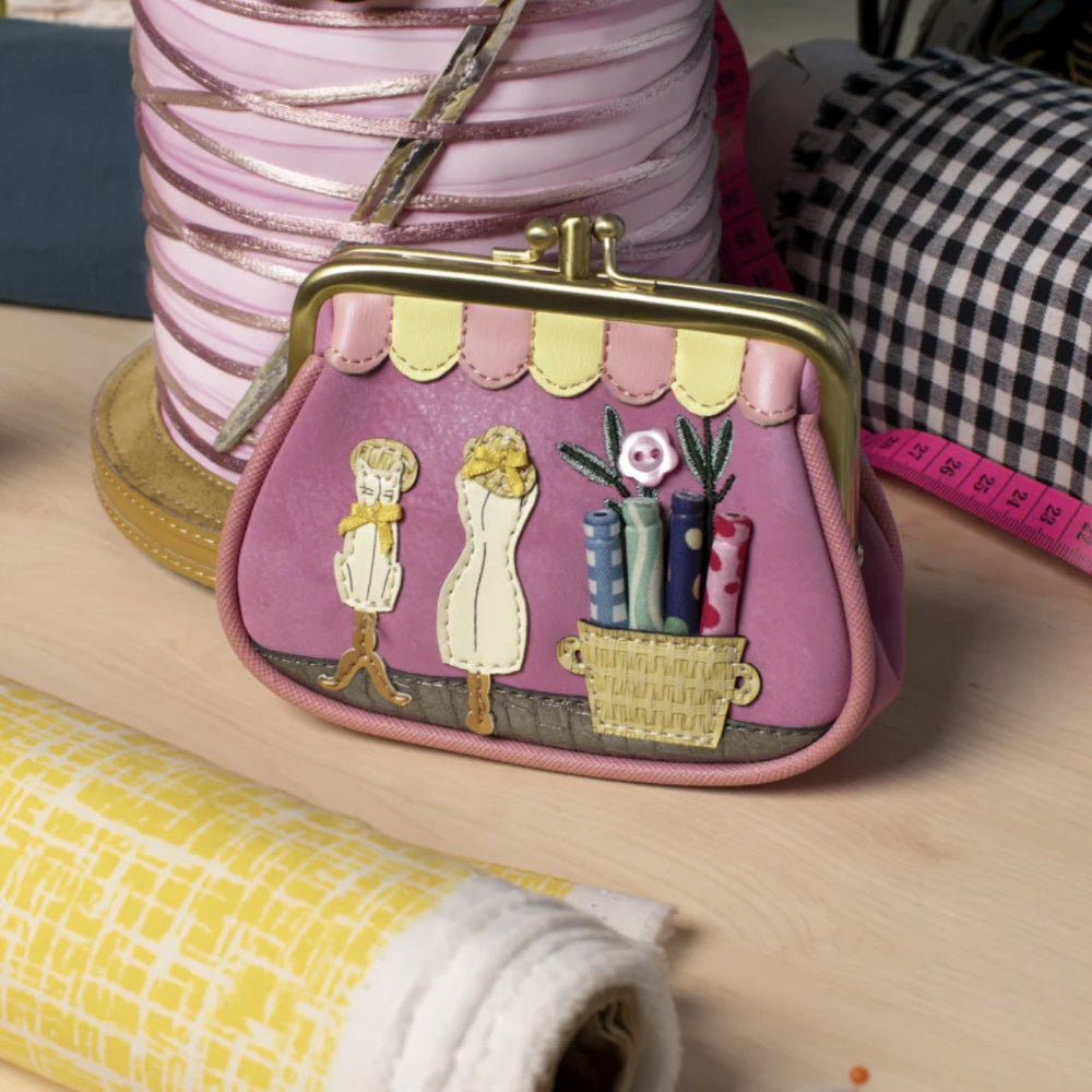 Pink purse with decorative elements on a wooden surface