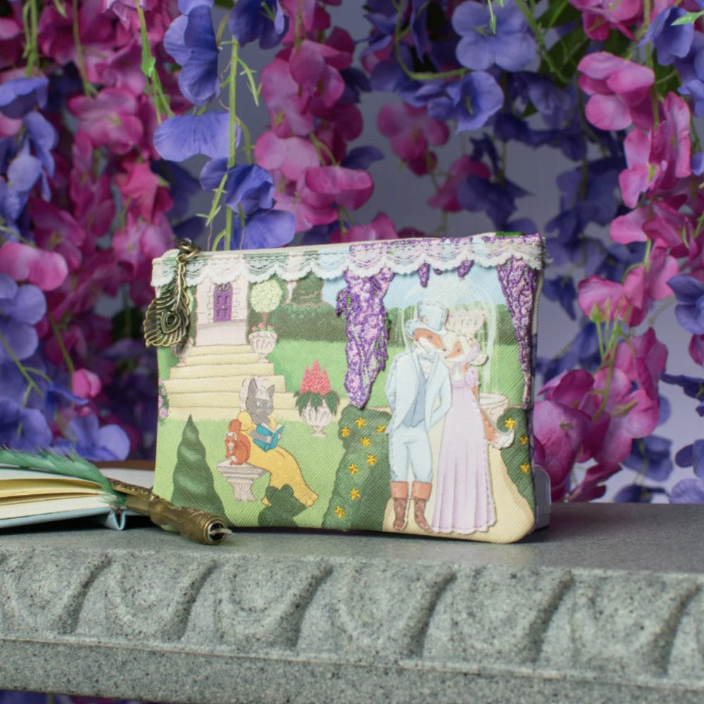 Small coin purse with fairy tale design on a surface with flowers in the background