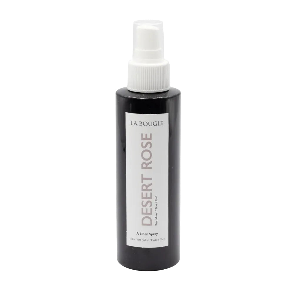 Black bottle of 'Desert Rose' linen spray by La Bougie on a light gray background