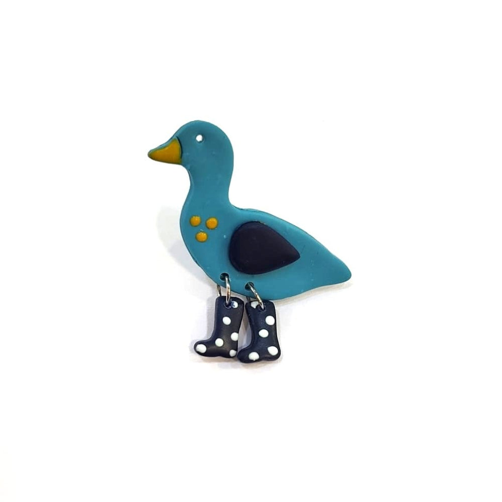 Blue duck-shaped brooch with a black heart on a white background