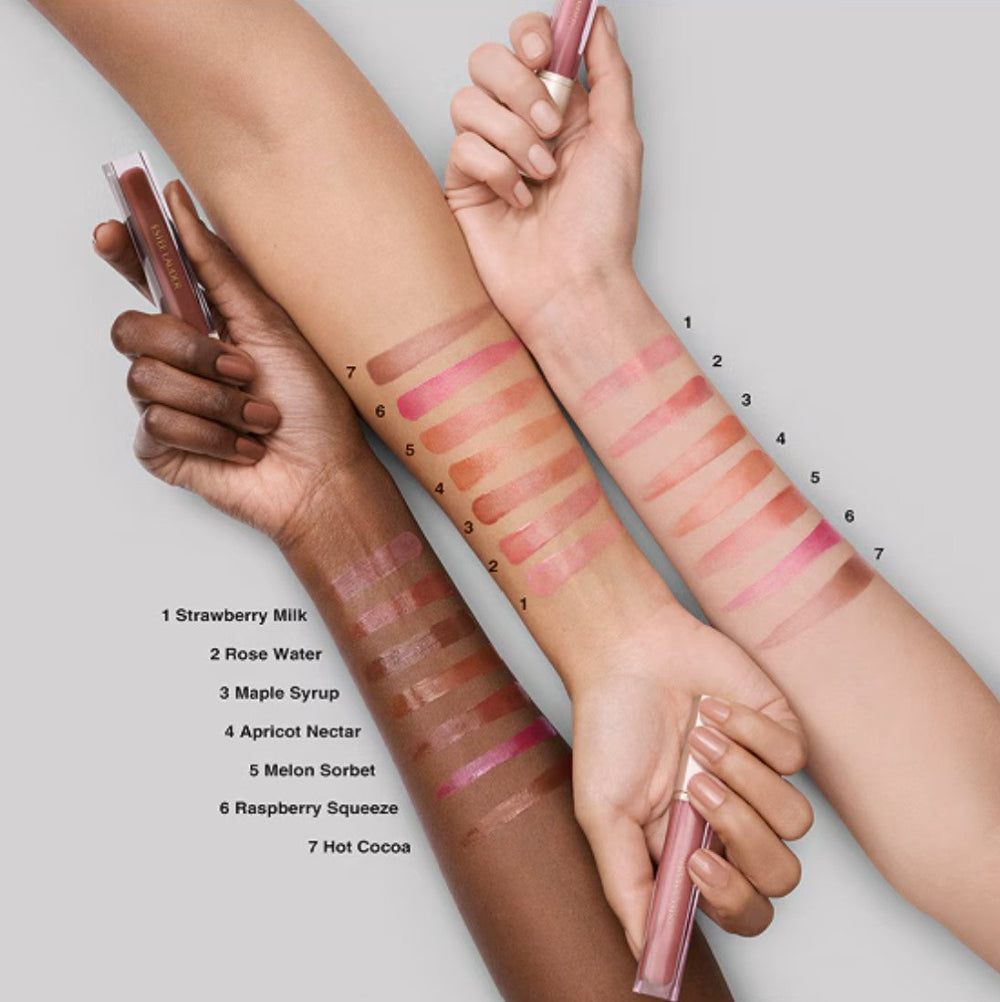 Lipstick swatches on a person's arm with labeled shades against a neutral background