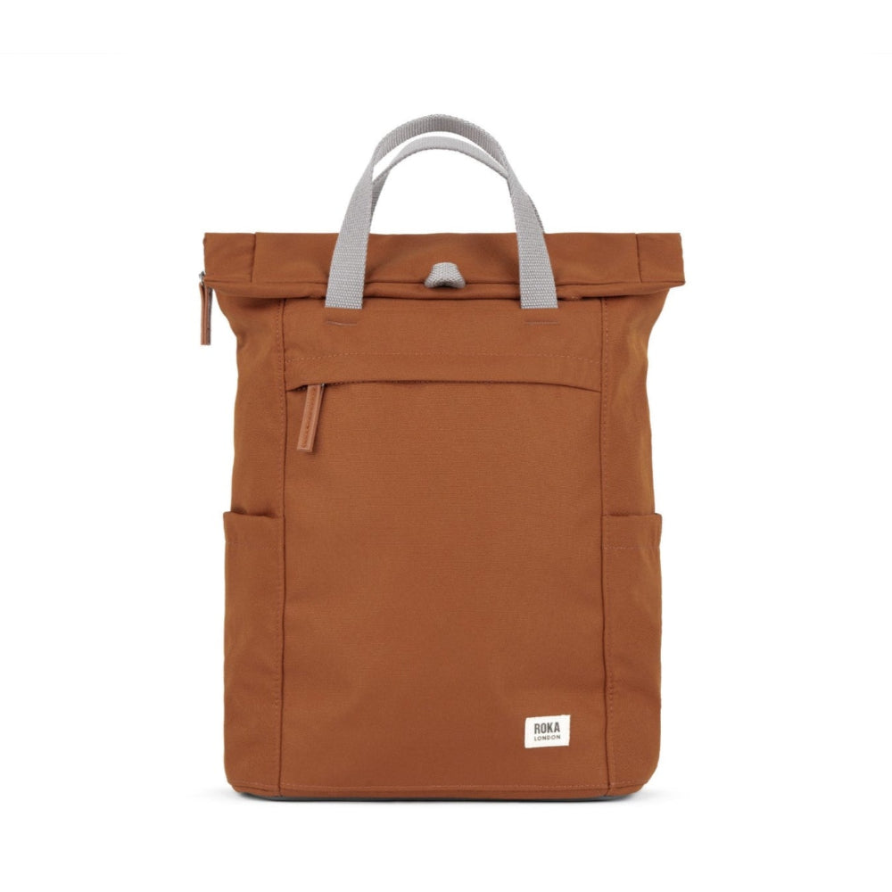 A medium-sized brown Roka Finchley A recycled canvas backpack with a front pocket and top handles.