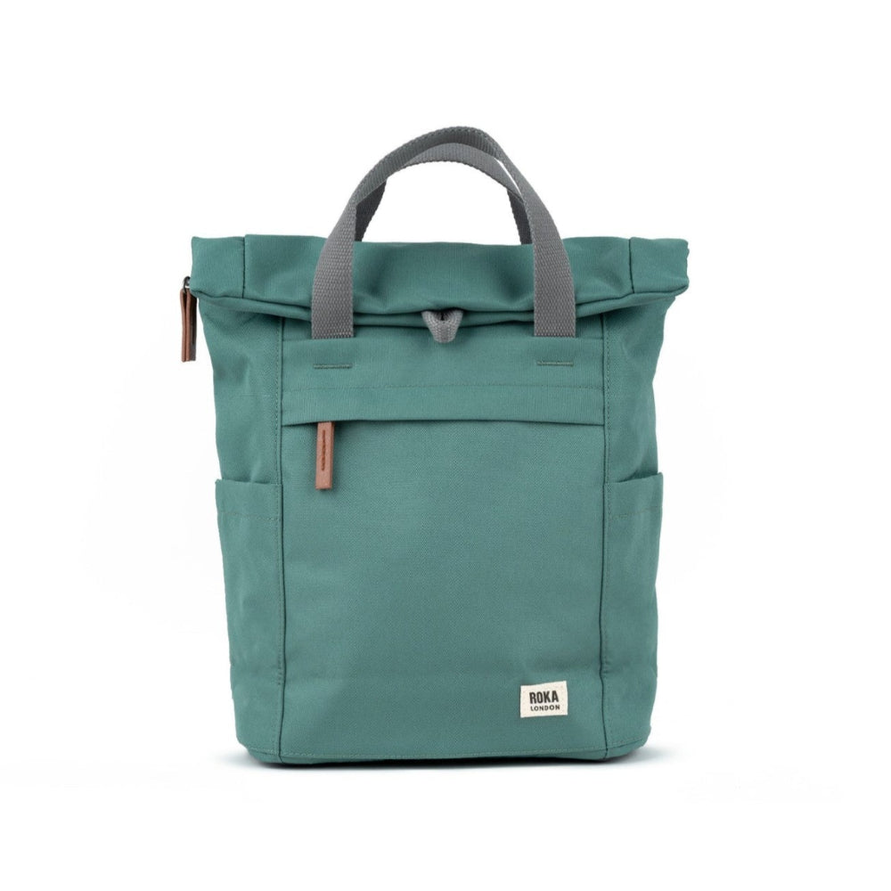 A medium-sized blue Roka Finchley A recycled canvas backpack with a front pocket and top handles.