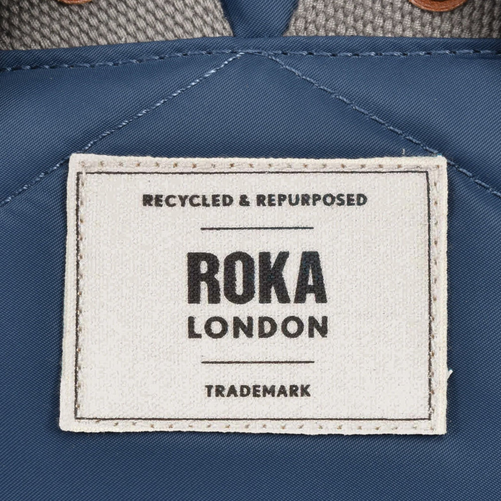 Roka London recycled and repurposed label on a blue fabric background