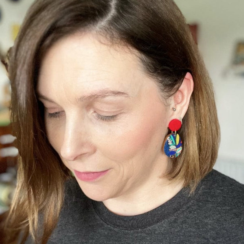 Woman wearing colorful earrings with a blurred background
