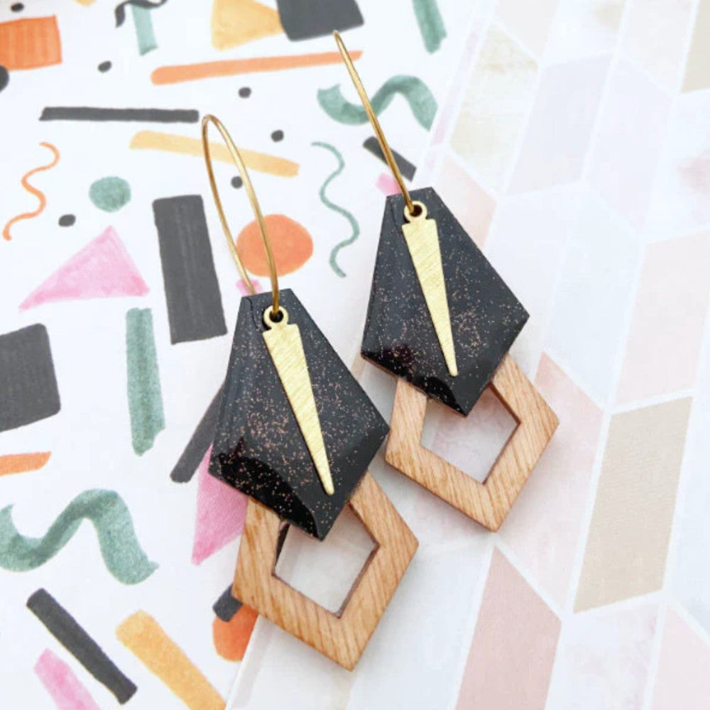 Geometric earrings on a colorful abstract background