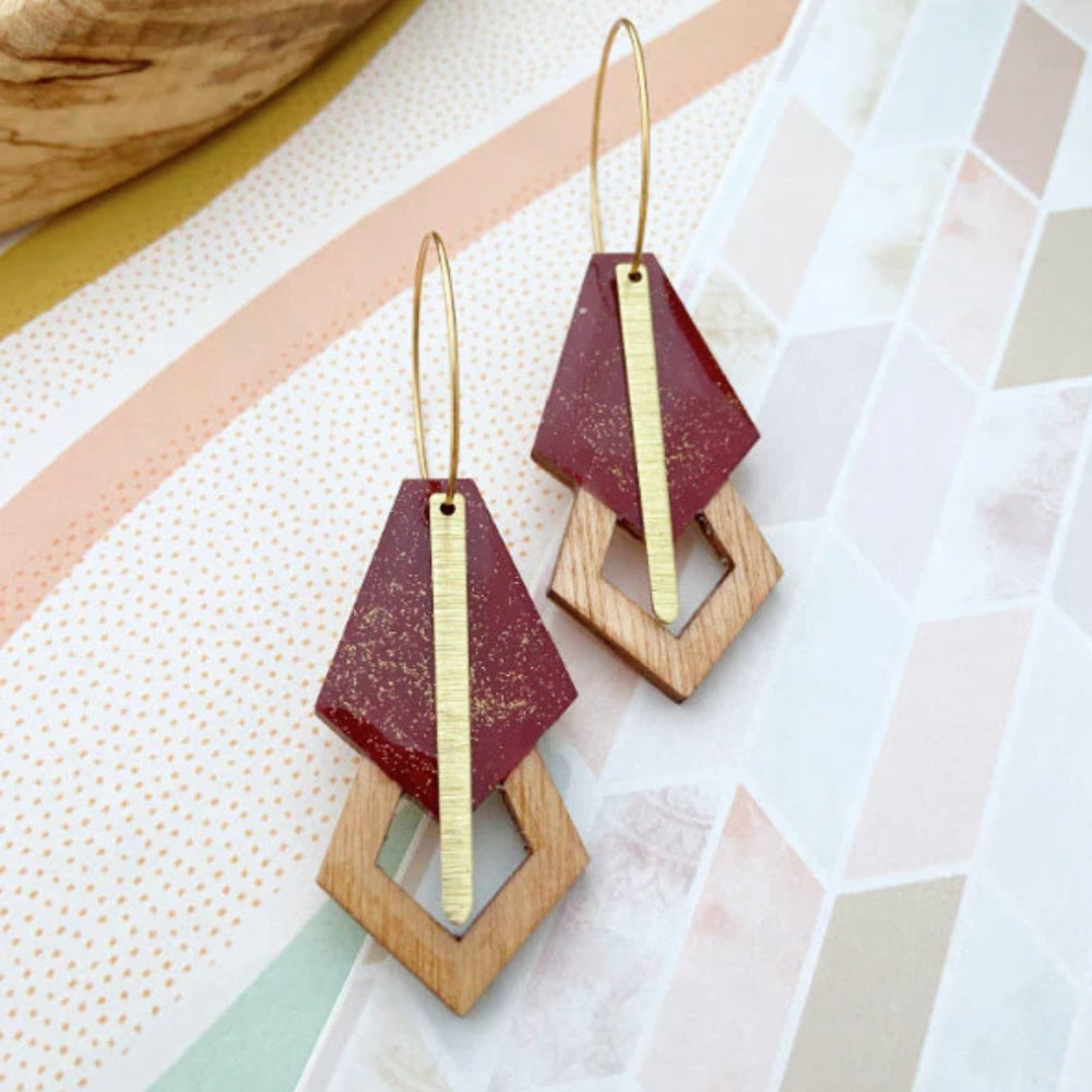Geometric wooden earrings on a colorful abstract background