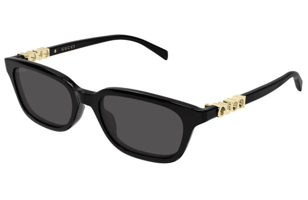 Gucci black sunglasses with dark gray lenses and gold-tone logo hardware on the temples, shown on a plain white background.
