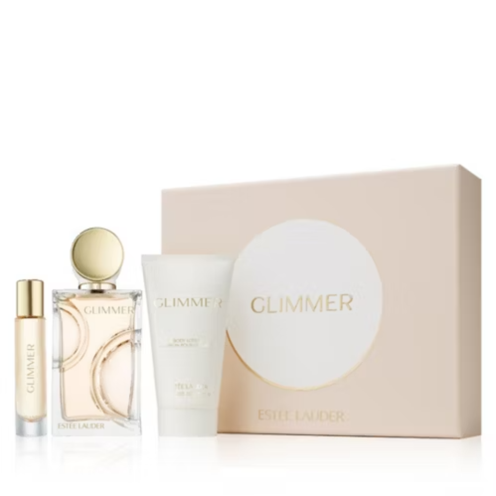 Estee Lauder Glimmer gift set featuring a small gold atomizer bottle, a clear glass perfume bottle with pale pink liquid and gold cap, a white body lotion tube, and a large blush pink rectangular box with a white oval and gold 'GLIMMER' text.