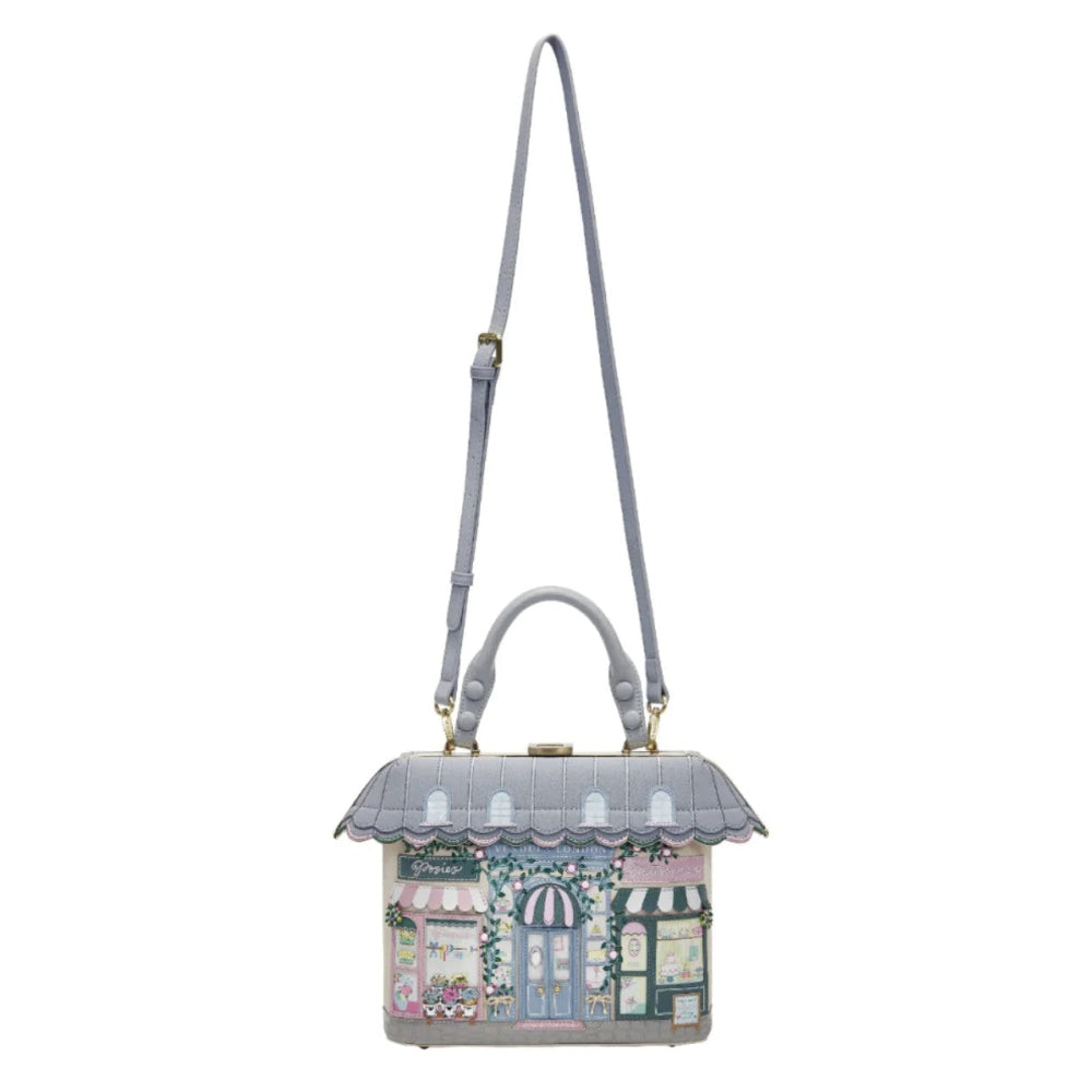 Handbag designed like a miniature building with a gray roof and colorful facade on a white background