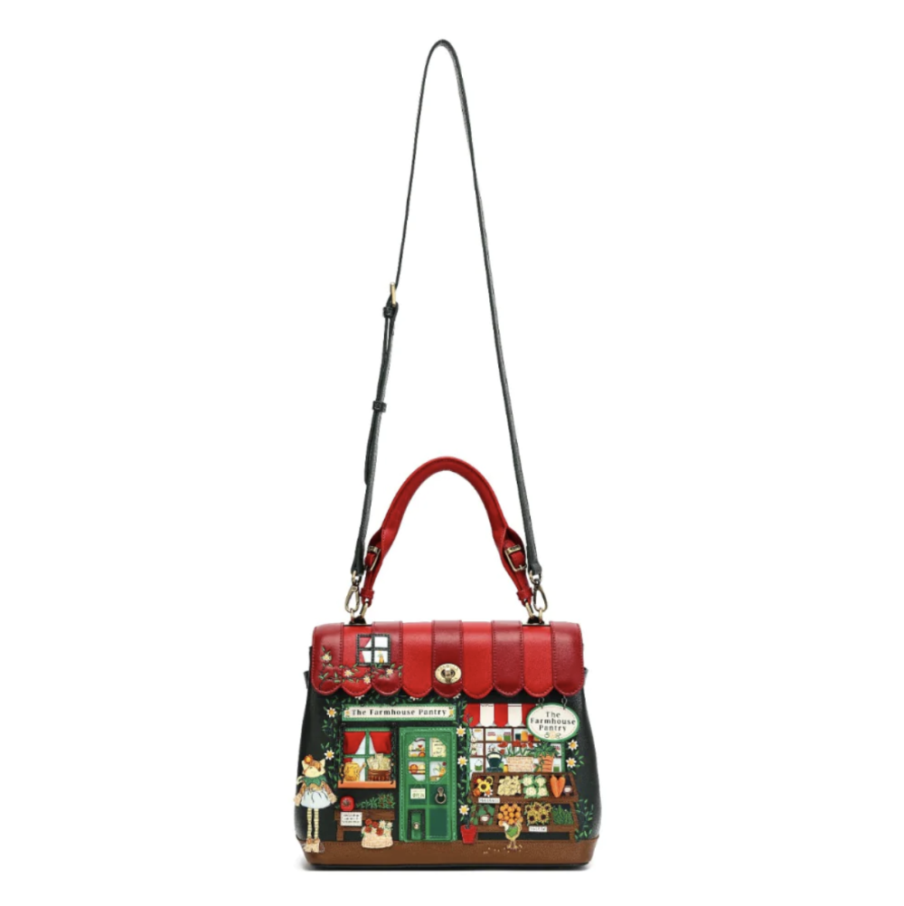 A structured handbag with a red top handle and shoulder strap, featuring a dark green front panel decorated.