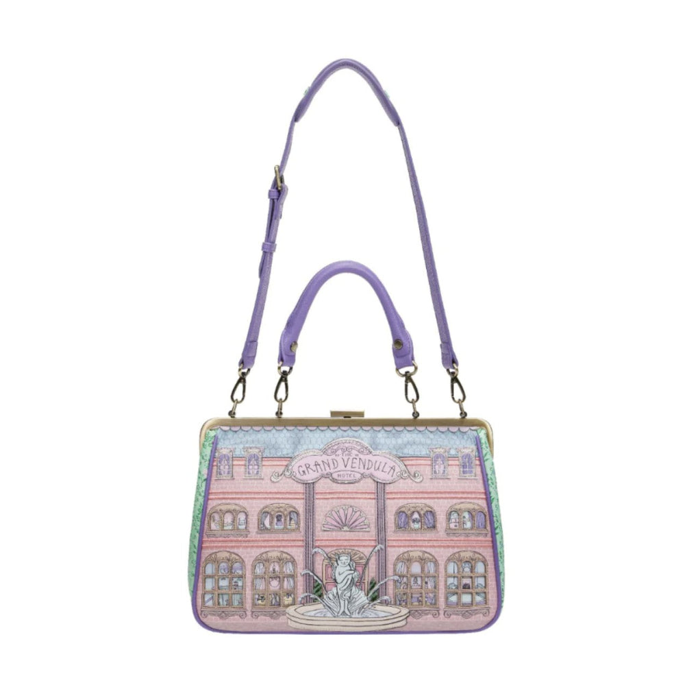 Handbag with a building design and purple strap on a white background