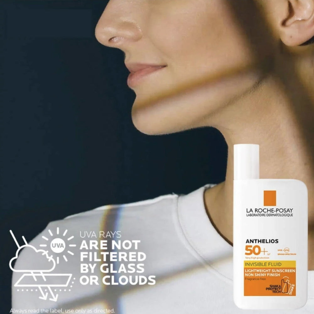 Woman applying sunscreen with La Roche-Posay Anthelios bottle displayed