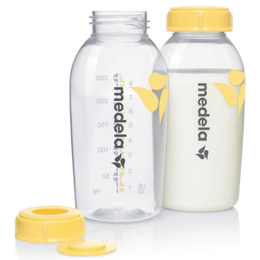 Two Medela baby bottles with yellow caps on a white background