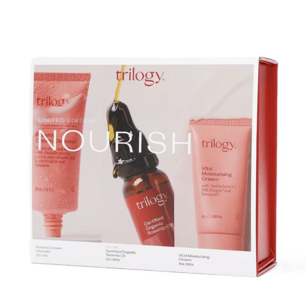 Trilogy Nourish Limited Edition skincare gift set in a white box with red side panels, showing three products: a pink cleanser tube, a dark amber serum dropper bottle, and a pink moisturizing cream tube.