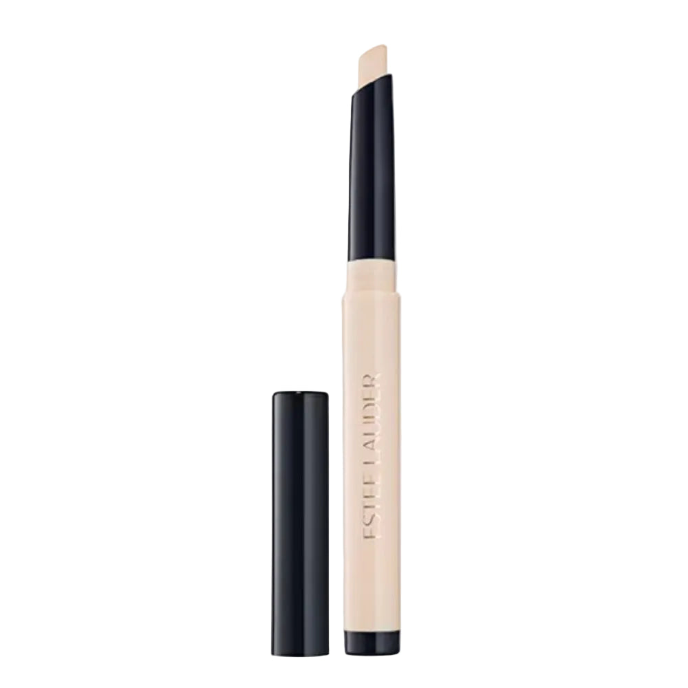 Estée Lauder Concealer Stick in a light beige shade, shown with its black cap removed and standing beside the open tube on a light gray background.