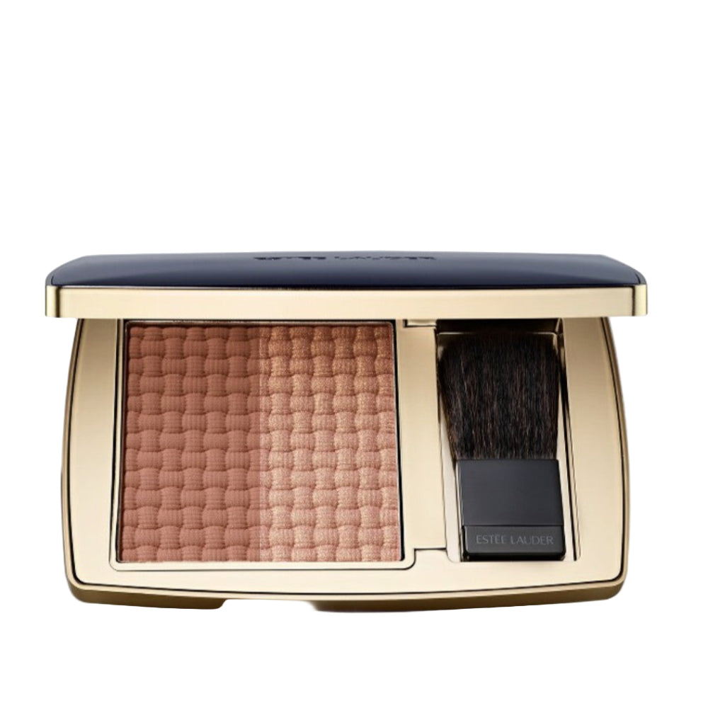 Compact powder with a brush in a gold case on a light gray background