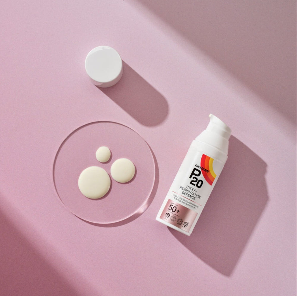 Sunscreen bottle labeled 'P20' on a pink background with cream pads.