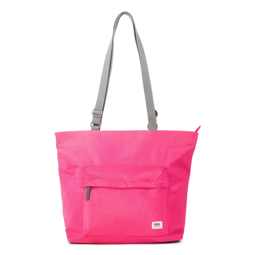 A bright pink medium tote bag made from recycled nylon, featuring adjustable grey straps and a front pocket.