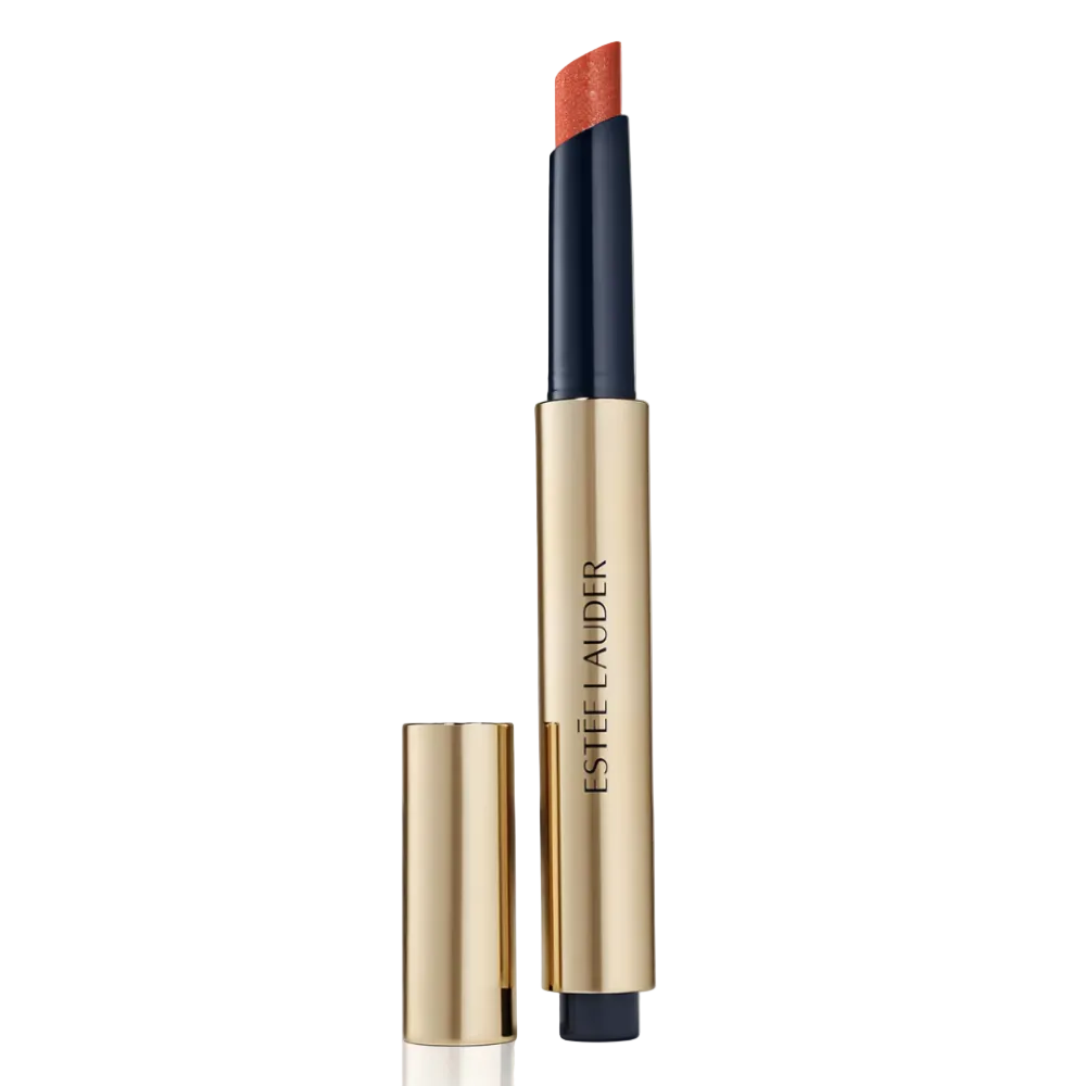 Estée Lauder lipstick in a gold and navy tube with the cap removed, showing a warm coral-orange lipstick bullet on a clean white background.