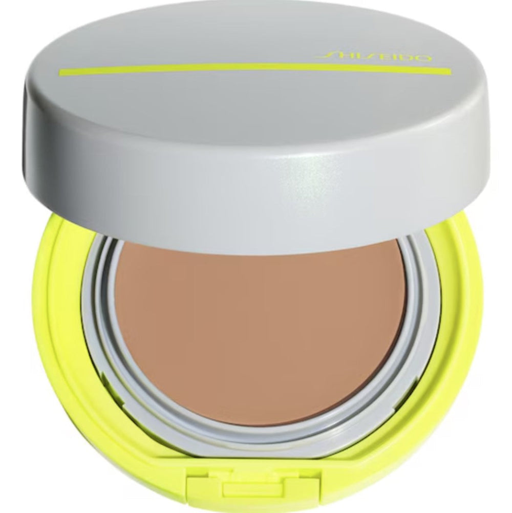 Compact powder in a yellow case with a gray lid on a white background