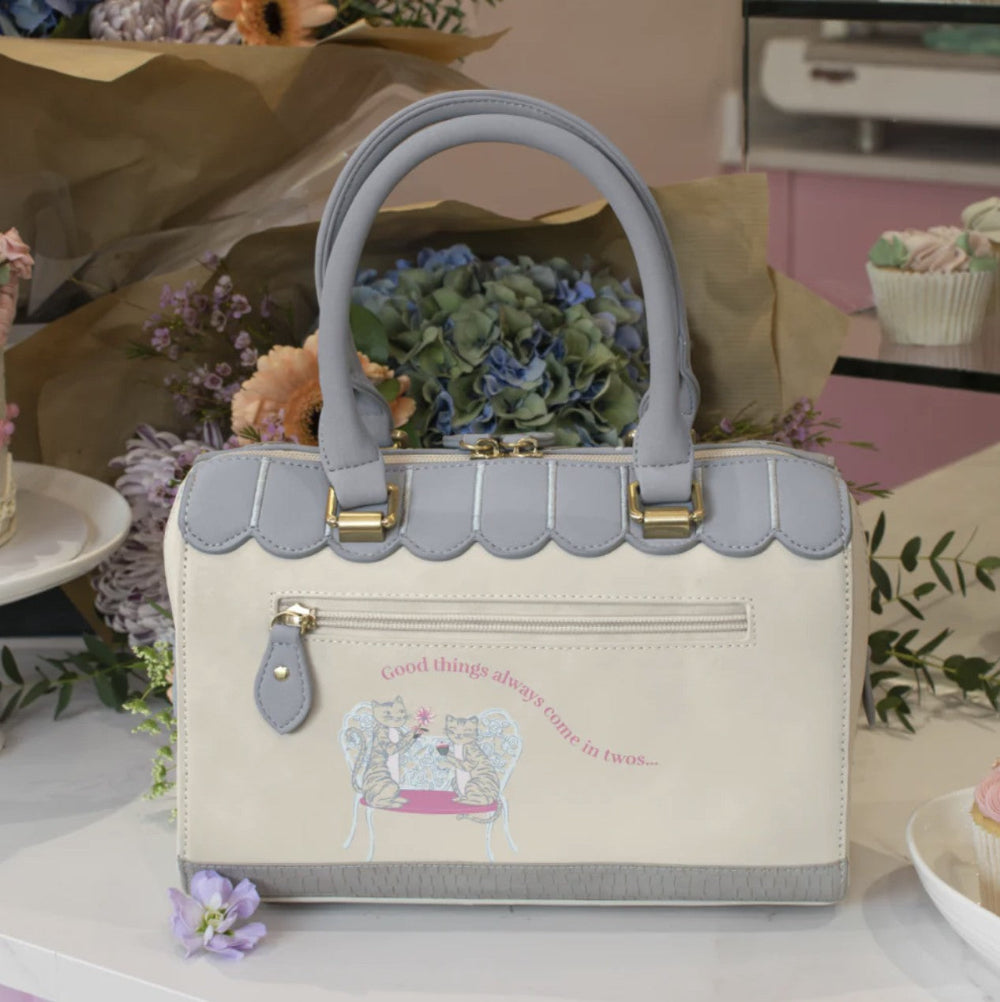 Handbag with scalloped edges on a decorative background with flowers and cupcakes.