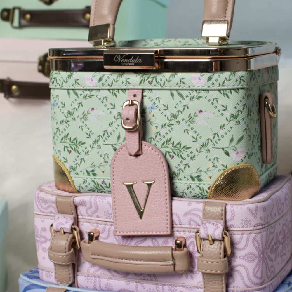 Floral-patterned handbag with a matching pink luggage tag on a light blue background